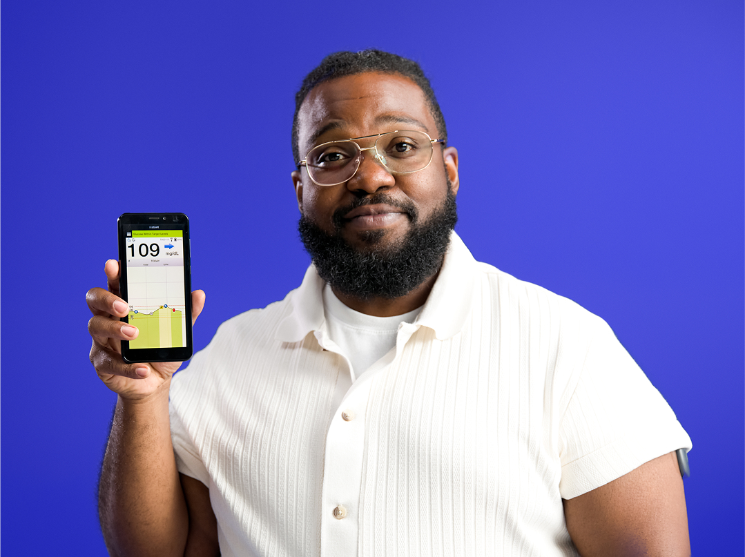  Eversense users holds iphone displaying CGM App compatibility