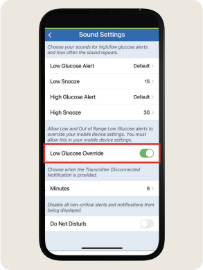 Smartphone screen displaying "Sound Settings" with options for glucose alerts. "Low Glucose Override" toggle is switched on.
